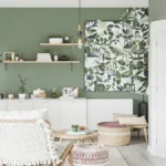 Salon moderne avec mur vert et déco végétale.