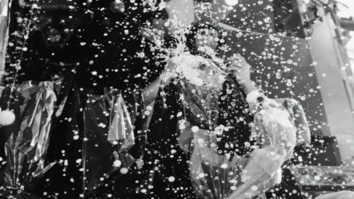 Une personne photographiant à travers gouttes d'eau scintillantes.