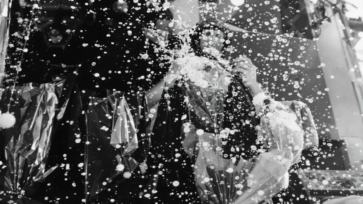 Une personne photographiant à travers gouttes d'eau scintillantes.